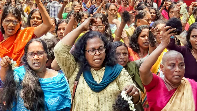ASHA workers cut their hair during a protest, demanding an increase in their honorarium, in Thiruvananthapuram. 