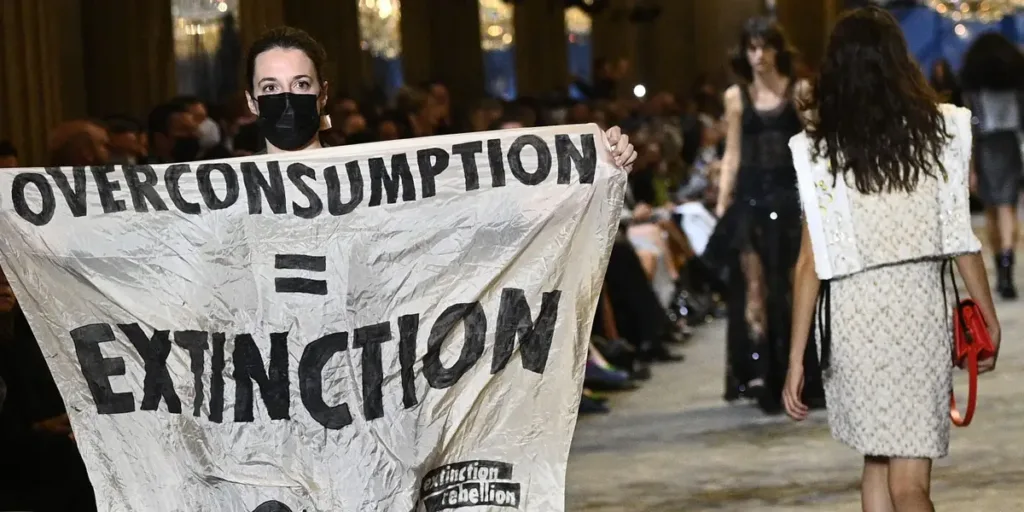 A protester stormed the runway at Louis Vuitton's Paris fashion show and was dragged out by security
